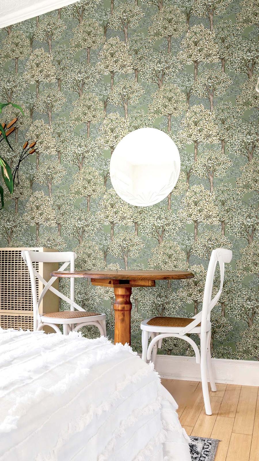 Papel de parede verde com padrão de árvores, junto a uma mesa redonda